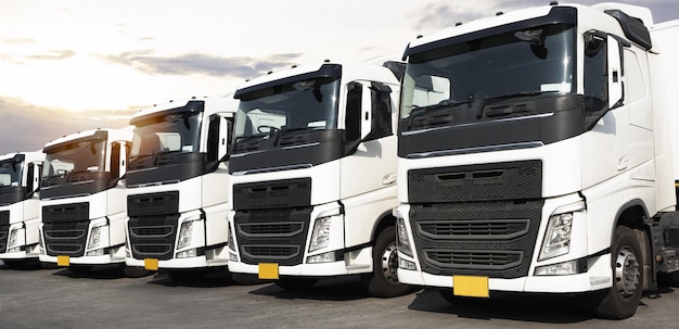 Semi trailer trucks parked lot with sunset sky diesel truck\
shipping freight trucks cargo transport