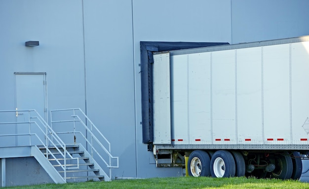 Photo semi truck delivery truck trailer in warehouse dock