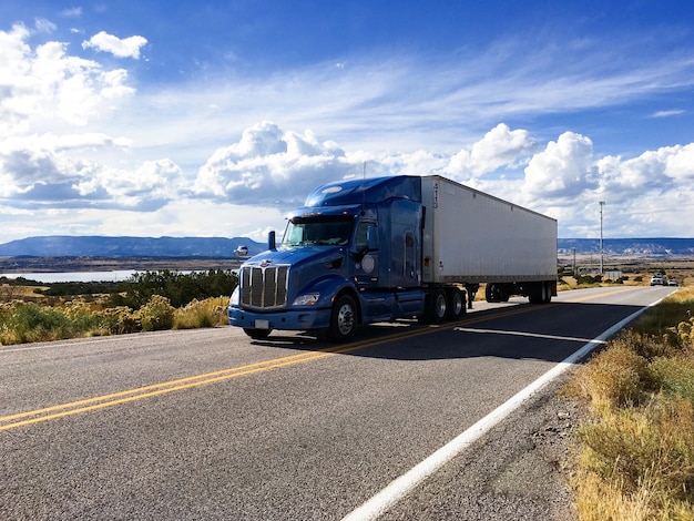 Photo semi-truck moving on highway against sky