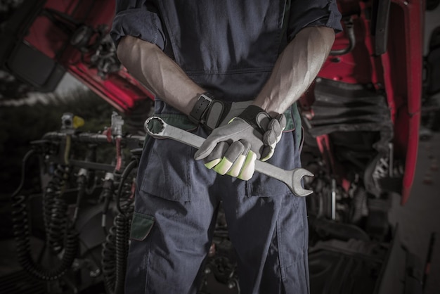 Foto semi truck pro mechanic caucasian service worker con heavy duty wrench che si prepara per una complicata riparazione di camion