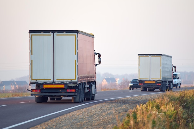 Semi-truck with cargo trailer driving on highway hauling goods in evening. Delivery transportation and logistics concept