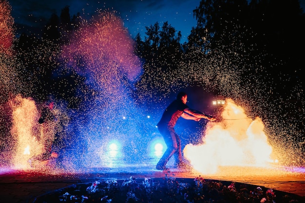 SEMIGORYE RUSLAND 17 JUNI 2022 Vuurshow 's nachts op festivalevenement Man met fakkels regelt een pyrotechnische uitvoering