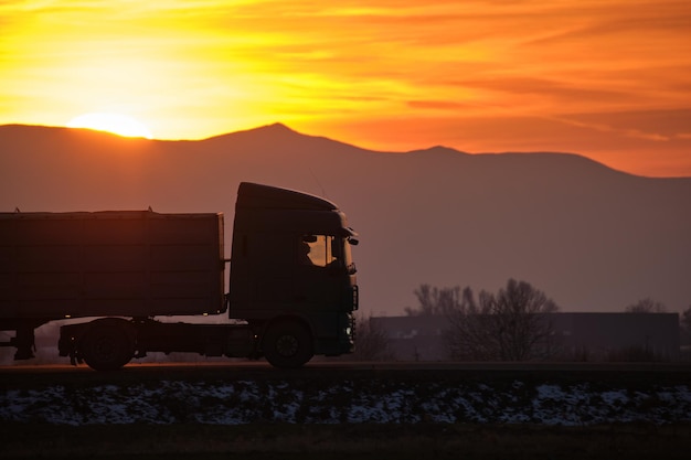 Foto semitruck met vrachtaanhangwagen die 's avonds op de snelweg rijdt en goederen vervoert leveringstransport en logistiek concept