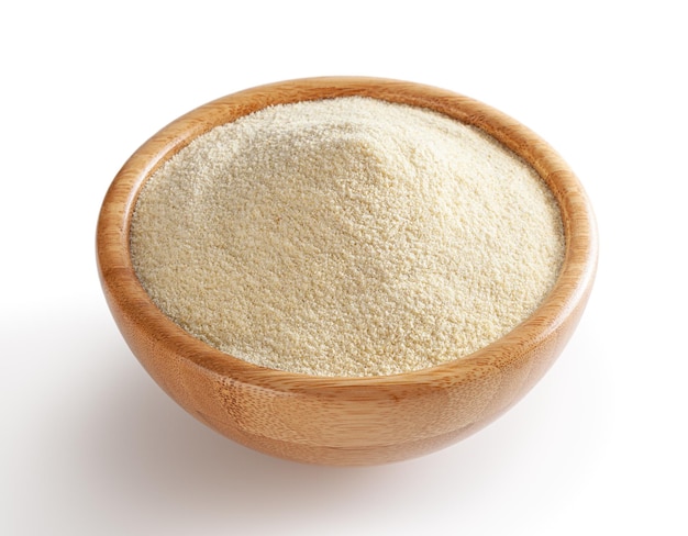 Semolina flour in wooden bowl isolated on white background with clipping path