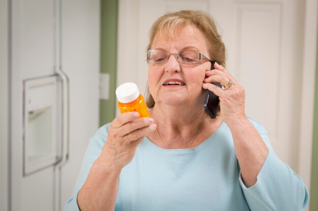 Senior Adult Woman on Cell Phone Holding Prescription Bottle