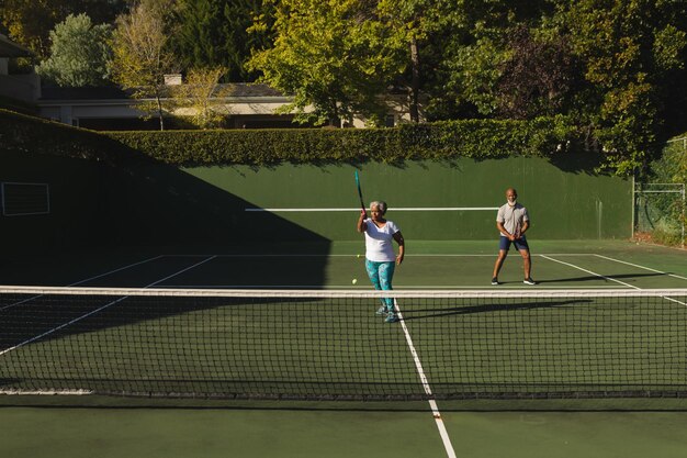 Foto una coppia afroamericana anziana che gioca a tennis sul campo da tennis