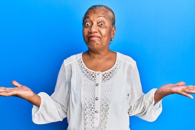 Senior african american woman wearing casual clothes clueless and confused with open arms no idea and doubtful face