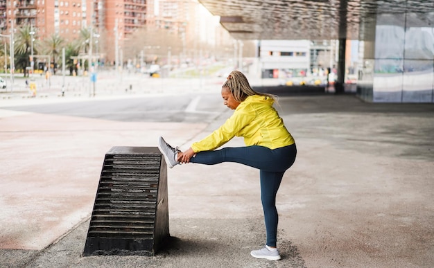 Foto donna africana anziana che si allunga all'aperto prima della routine di jogging mattutina sport e concetto di stile di vita sano concentrarsi sul viso