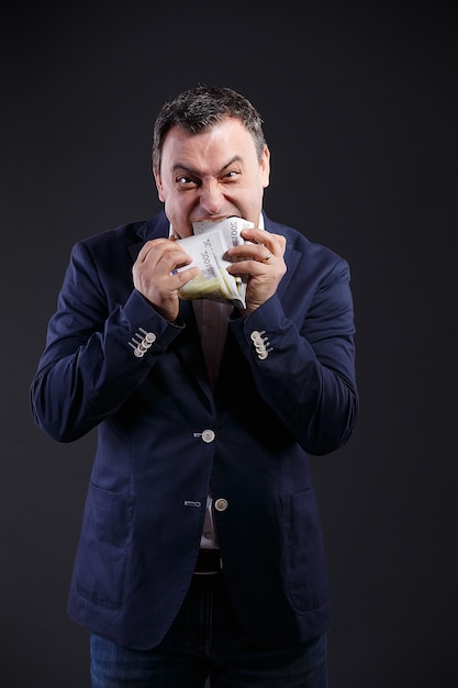 Photo senior aged business man eating euro bills