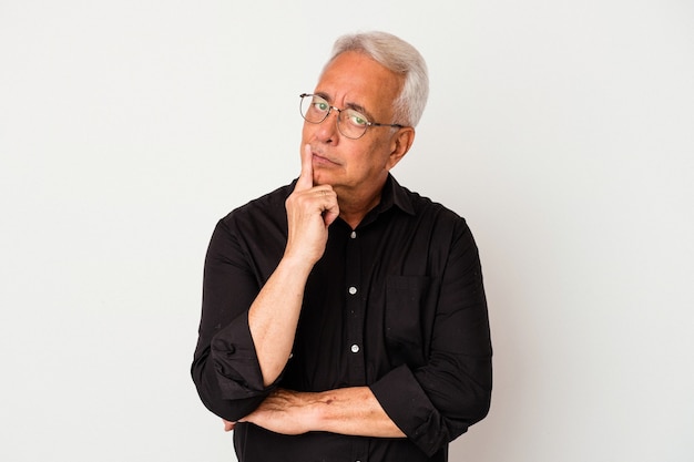 Senior american man isolated on white background looking sideways with doubtful and skeptical expression.