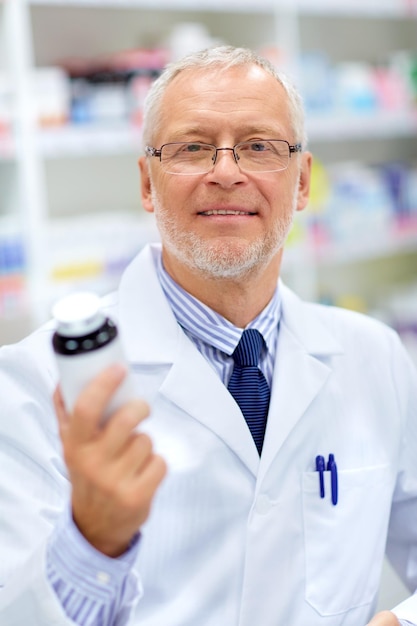 Photo senior apothecary with drug at pharmacy