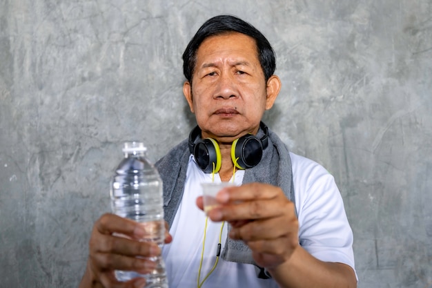 Senior Asian man worry in sportswear holding medicine.