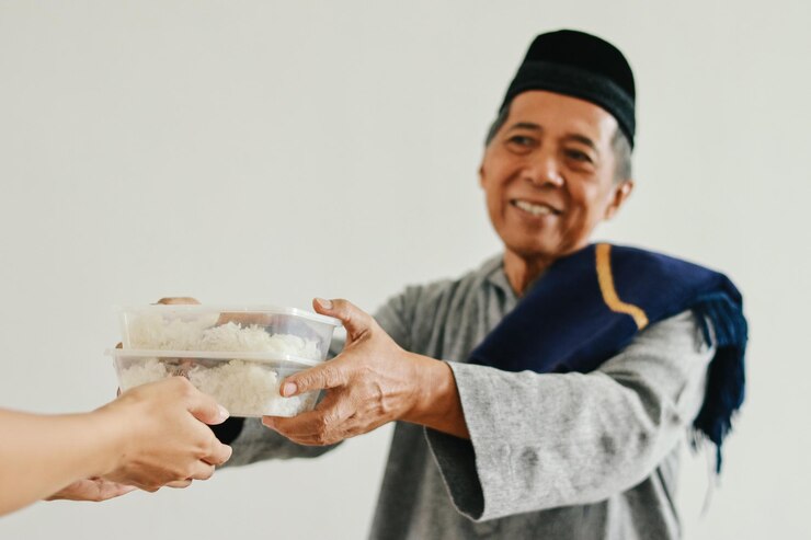 Photo senior asian muslim man giving food donation to the poor and needy in ramadan selective focus focu