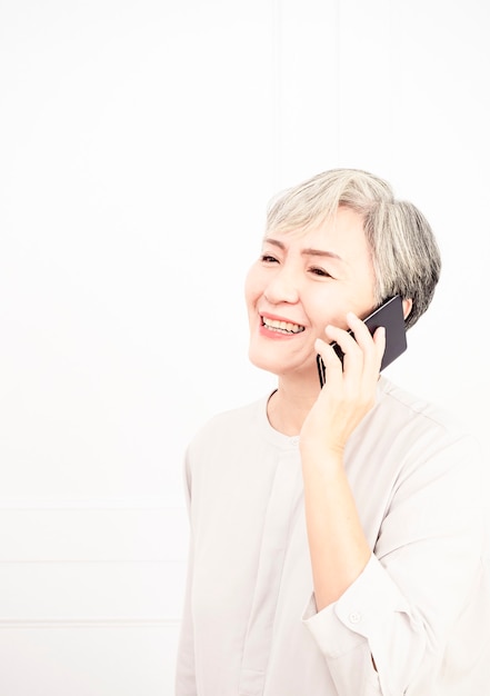 Senior asian woman has a happy conversation at cellphone.