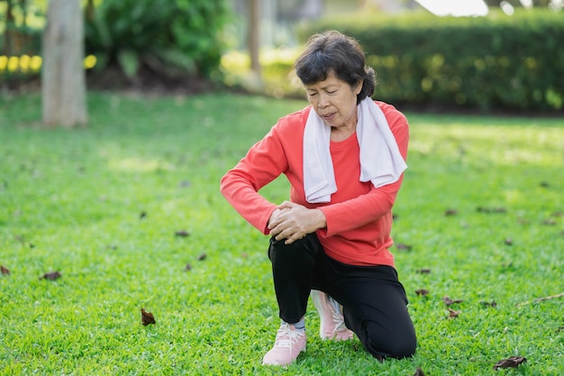 Senior asian woman with knee ankle pain while running in park
senior asian woman sitting on the ground and holding painful
knee