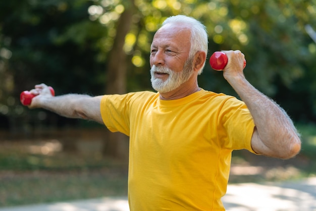 Senior athlete exercising outside An older man uses weights to exercise outdoor