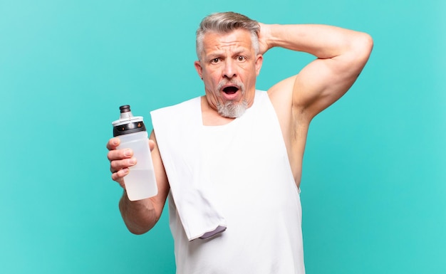 Senior athlete man feeling stressed, worried, anxious or scared, with hands on head, panicking at mistake