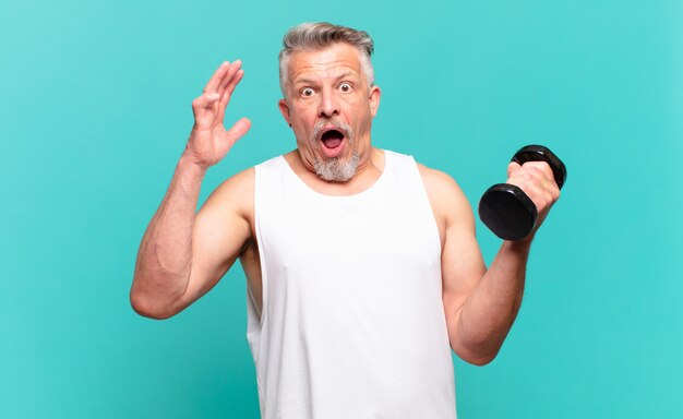 Senior athlete man screaming with hands up in the air, feeling furious, frustrated, stressed and upset