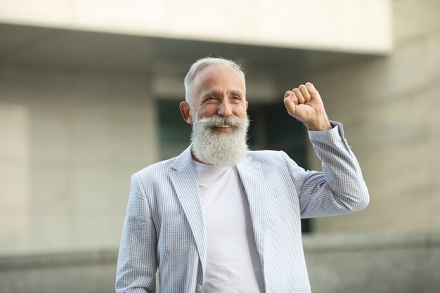 Senior baard man verhogen vuist