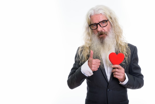 senior bearded businessman holding red heart