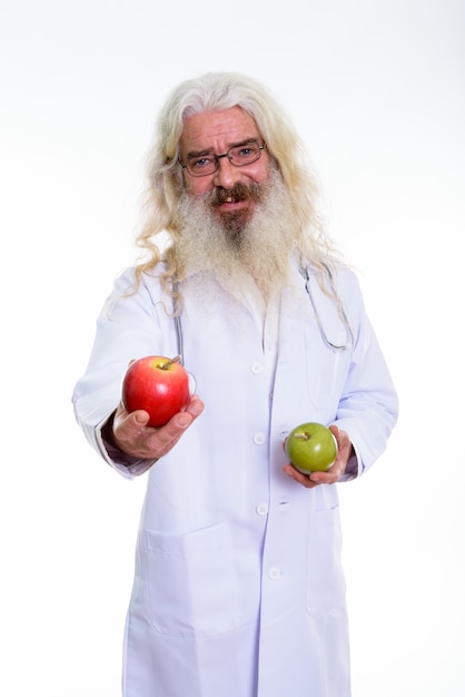 старший бородатый мужчина доктор держит красное яблоко и зеленое яблоко