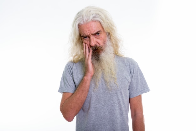 senior bearded man looking upset with hand on face