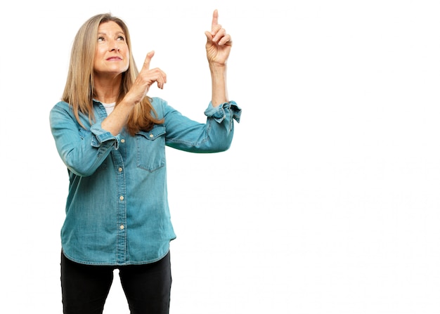 senior beautiful woman smiling and pointing upwards with both hands, towards the place where the pub