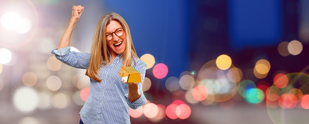 Senior beautiful woman with a gold ingot