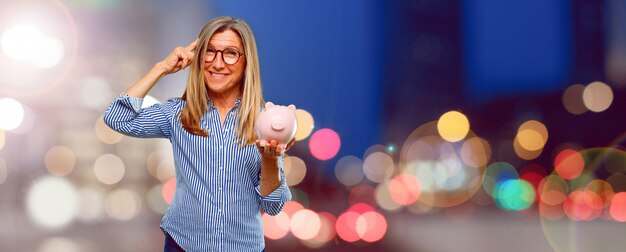 Senior beautiful woman with a piggy bank