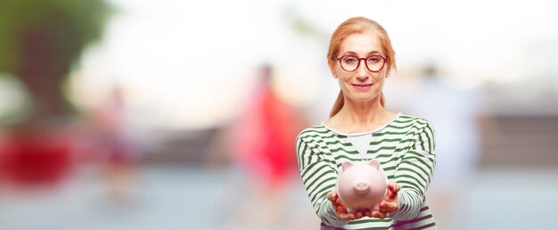 Senior beautiful woman with a piggy bank