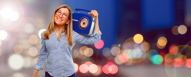 Senior beautiful woman with a vintage radio