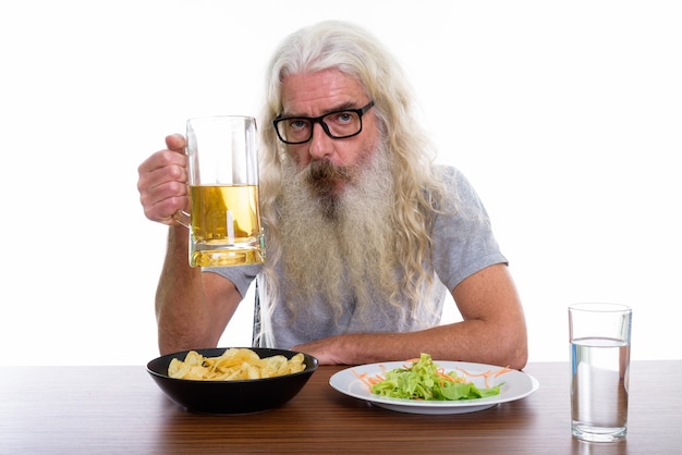 senior bebaarde man met glas bier