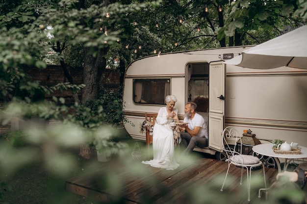 Senior beloved couple communicating sitting near cozy van