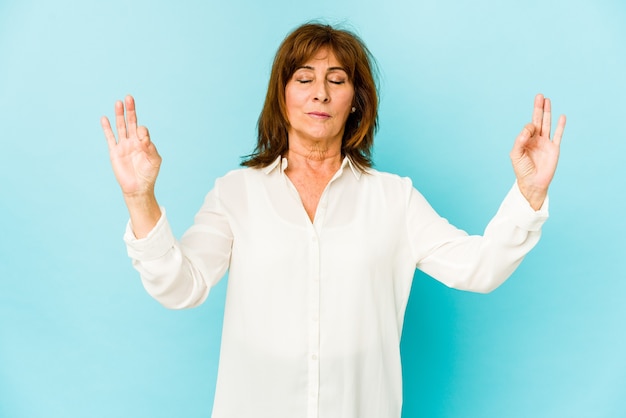 Senior blanke vrouw geïsoleerd ontspant na een zware werkdag, ze voert yoga uit.