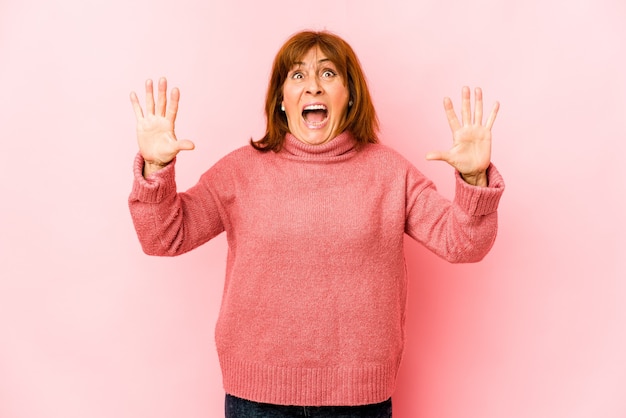 Senior blanke vrouw geïsoleerd schreeuwen naar de lucht, opzoeken, gefrustreerd.