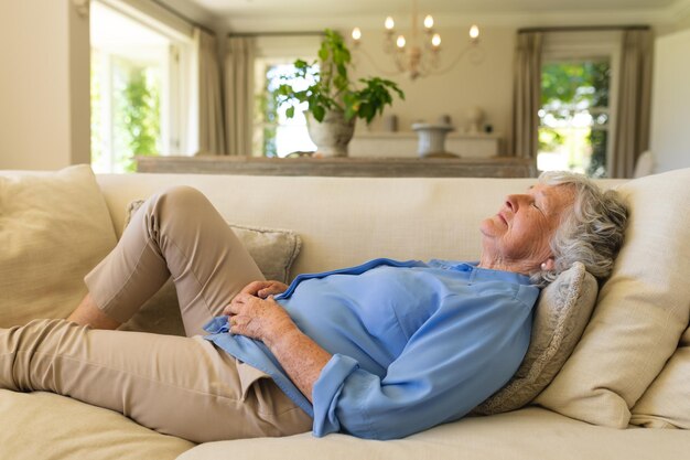 Foto senior blanke vrouw liggend op de bank met gesloten ogen. retraite, pensioen en gelukkig senior levensstijlconcept.