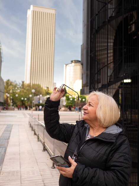 Foto senior blonde zakenvrouw kijkt naar haar bril.