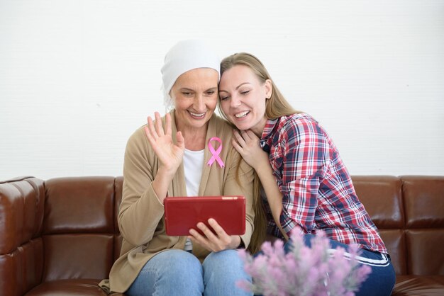 The senior breast cancer patient and her daughter use tablet to conversation by webcam