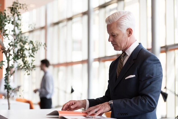 senior business man reading magazine at modern bright office