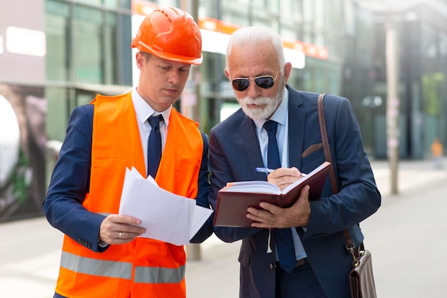Senior business man taking a notes Engineer man give a advice to senior man