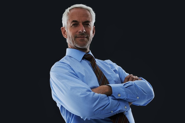 Senior businessman and portrait or arms crossed with smile in studio with confidence and pride for corporate career Mature entrepreneur and ceo with face thoughtful and mockup on black background