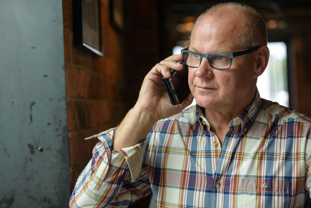 Senior businessman talking on the phone at the coffee shop