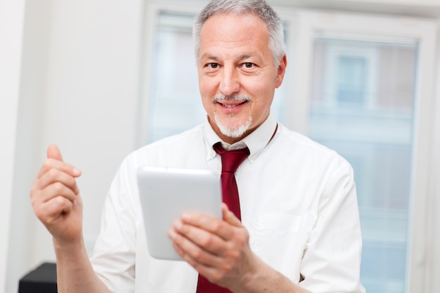 Senior businessman using his tablet