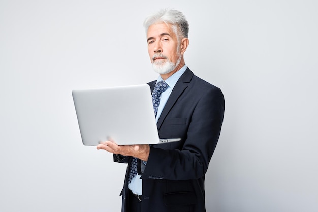 Photo senior businessman using laptop on white background