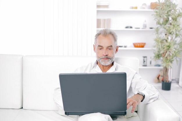 Senior businessman working on laptop in his office.