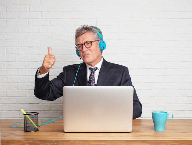 Senior businessman working  with his laptop and listening music 