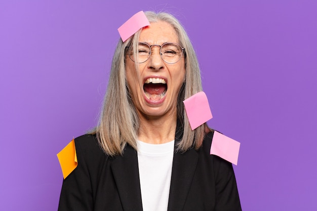 Senior businesswoman with adhesive post. humorous business concept