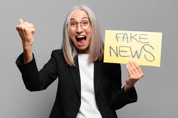 Senior businesswoman with fake news banner