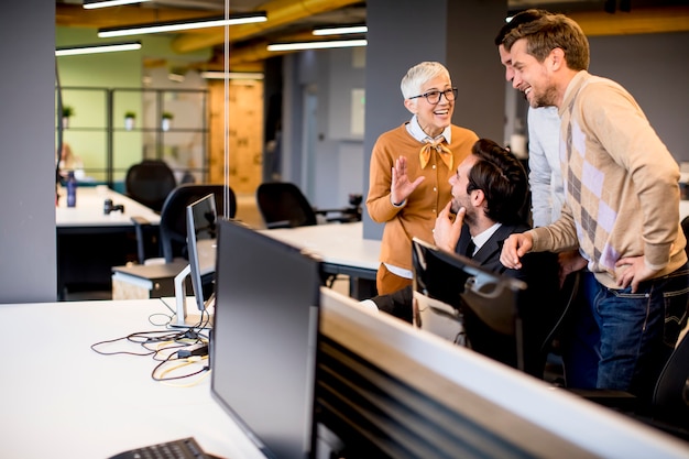 Senior businesswoman working together with young business people in office