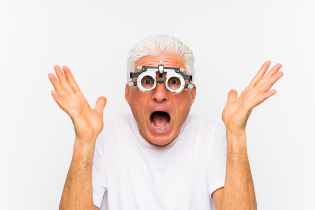 Senior caucasian man wearing a optometrist trial frame celebrating a victory or success